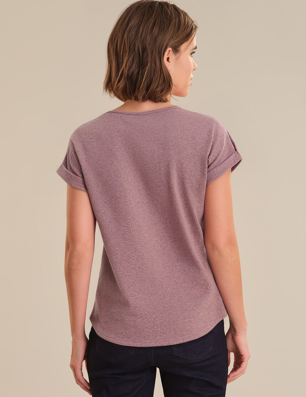 Woman wearing a purple t-shirt against a beige background