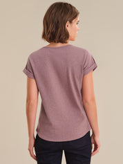 Woman wearing a purple t-shirt against a beige background