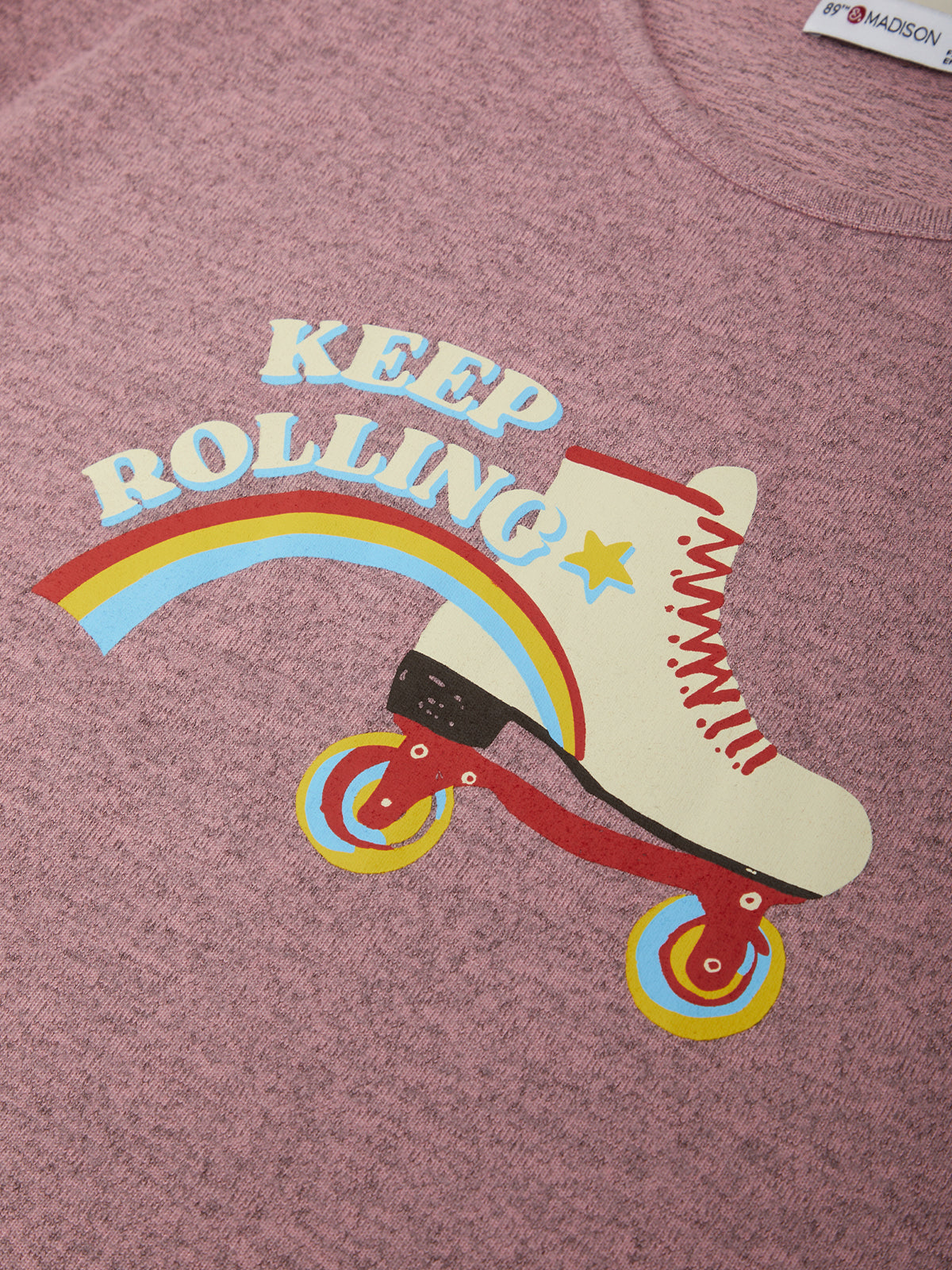 T-shirt with a roller skate graphic and 'Keep Rolling' text on a maroon background