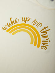 Yellow rainbow with 'wake up and thrive' text on a white background