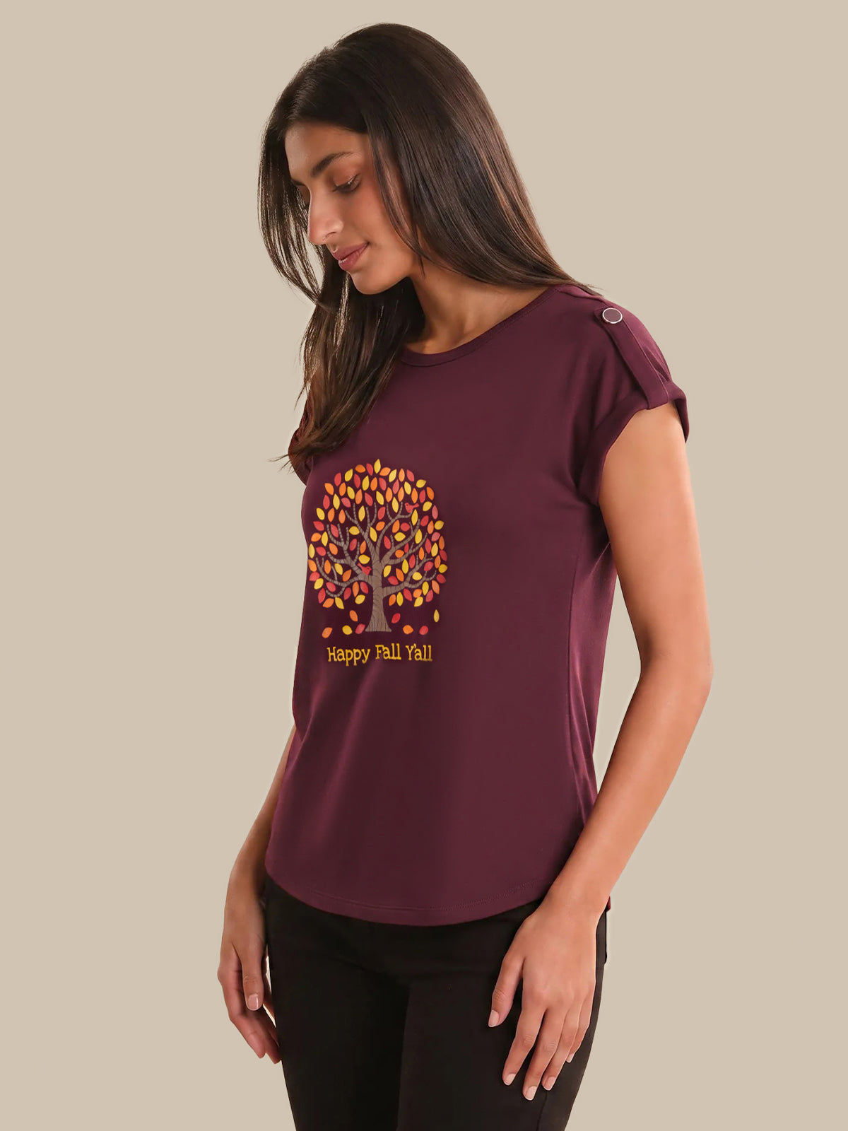 Woman wearing a maroon t-shirt with a colorful tree design and text on a beige background
