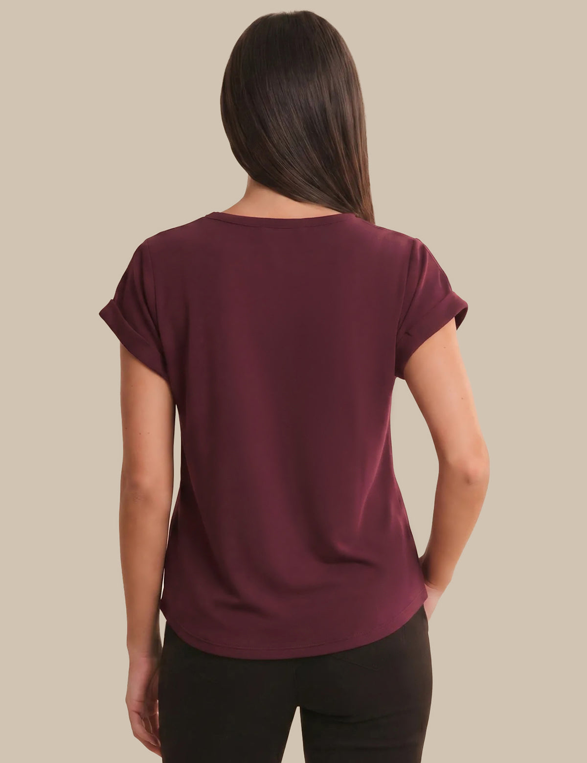 Woman wearing a maroon t-shirt against a beige background