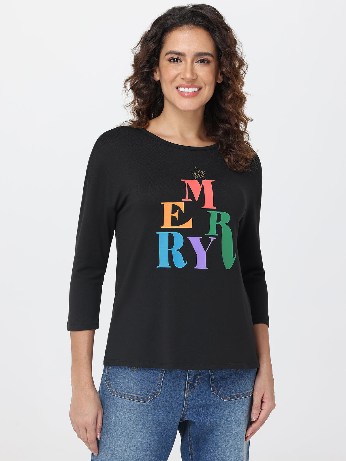 Woman wearing a black long-sleeve shirt with colorful letters spelling 'MERRY' on a white background