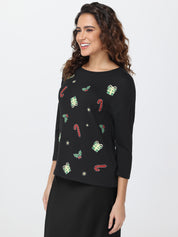 Woman wearing a top sweater with festive patterns on a white background