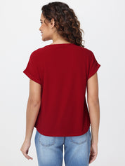 Woman wearing a red t-shirt and blue jeans on a white background