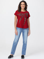Woman wearing a red t-shirt with a leopard print design and blue jeans on a white background