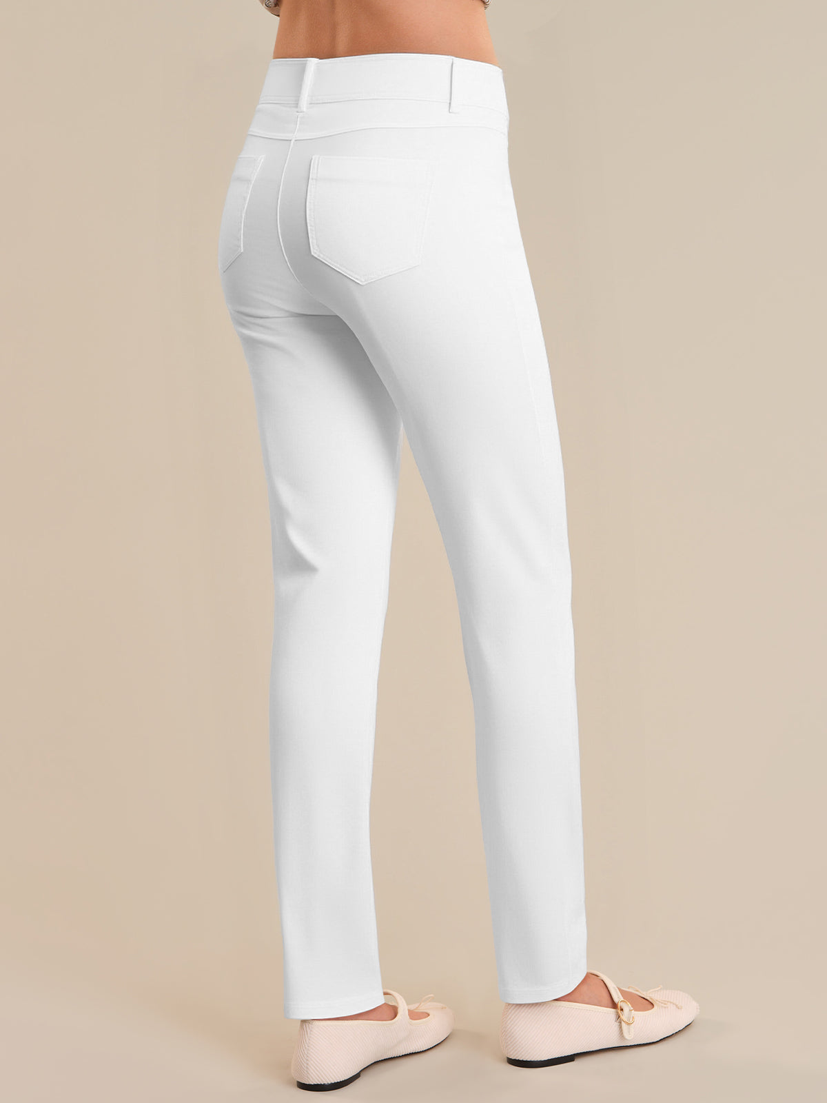 White pants worn by a person on a beige background