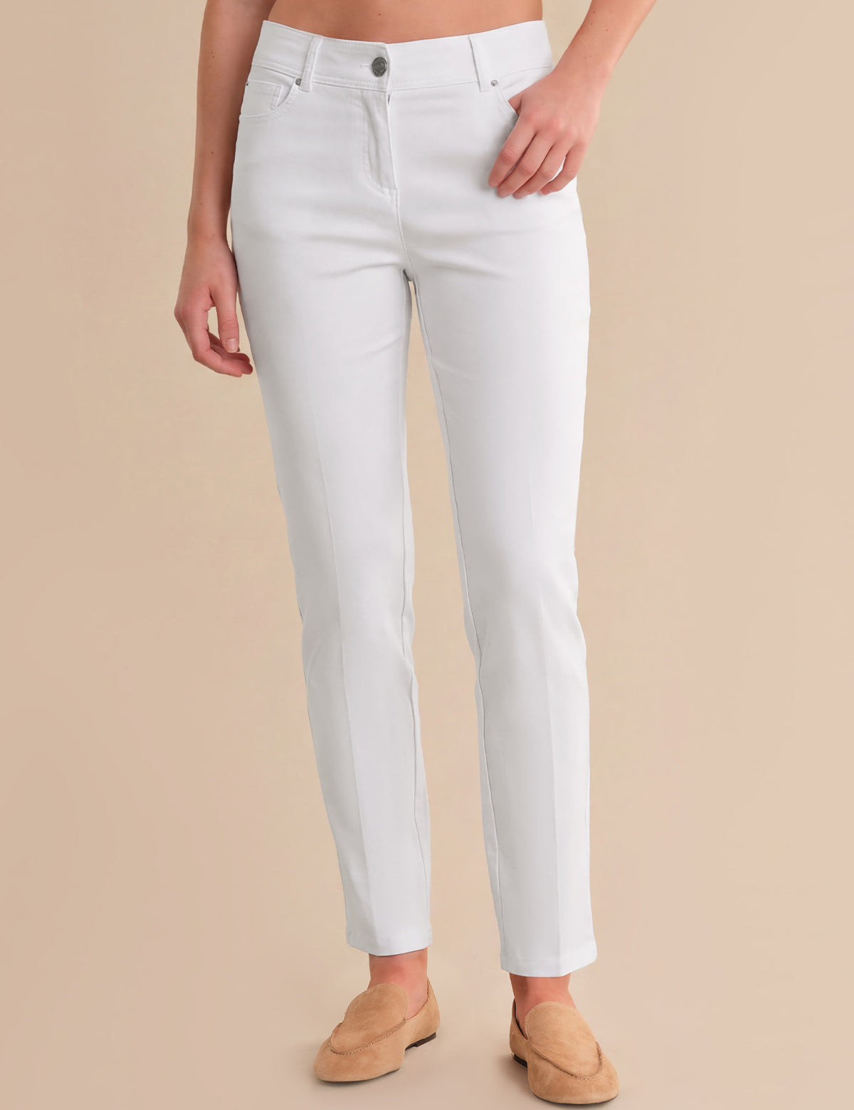 Person wearing white pants on a beige background
