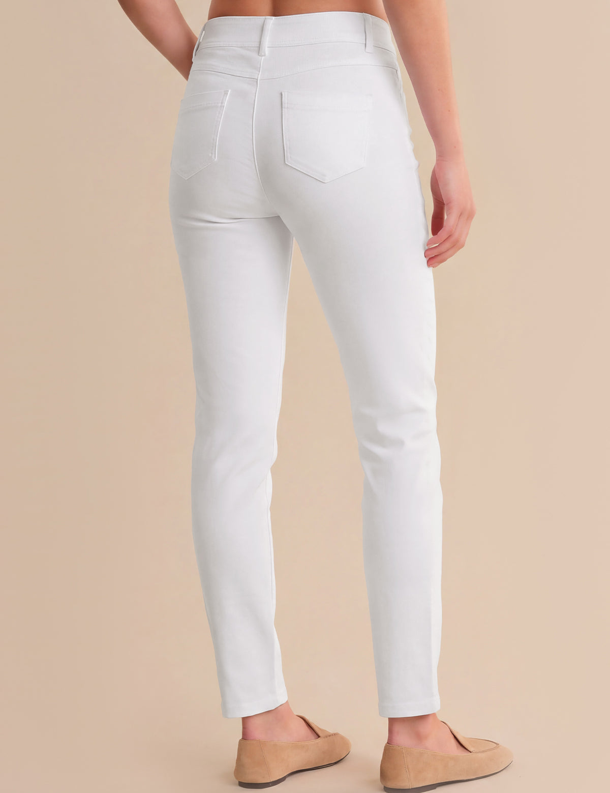 White pants worn by a person on a beige background