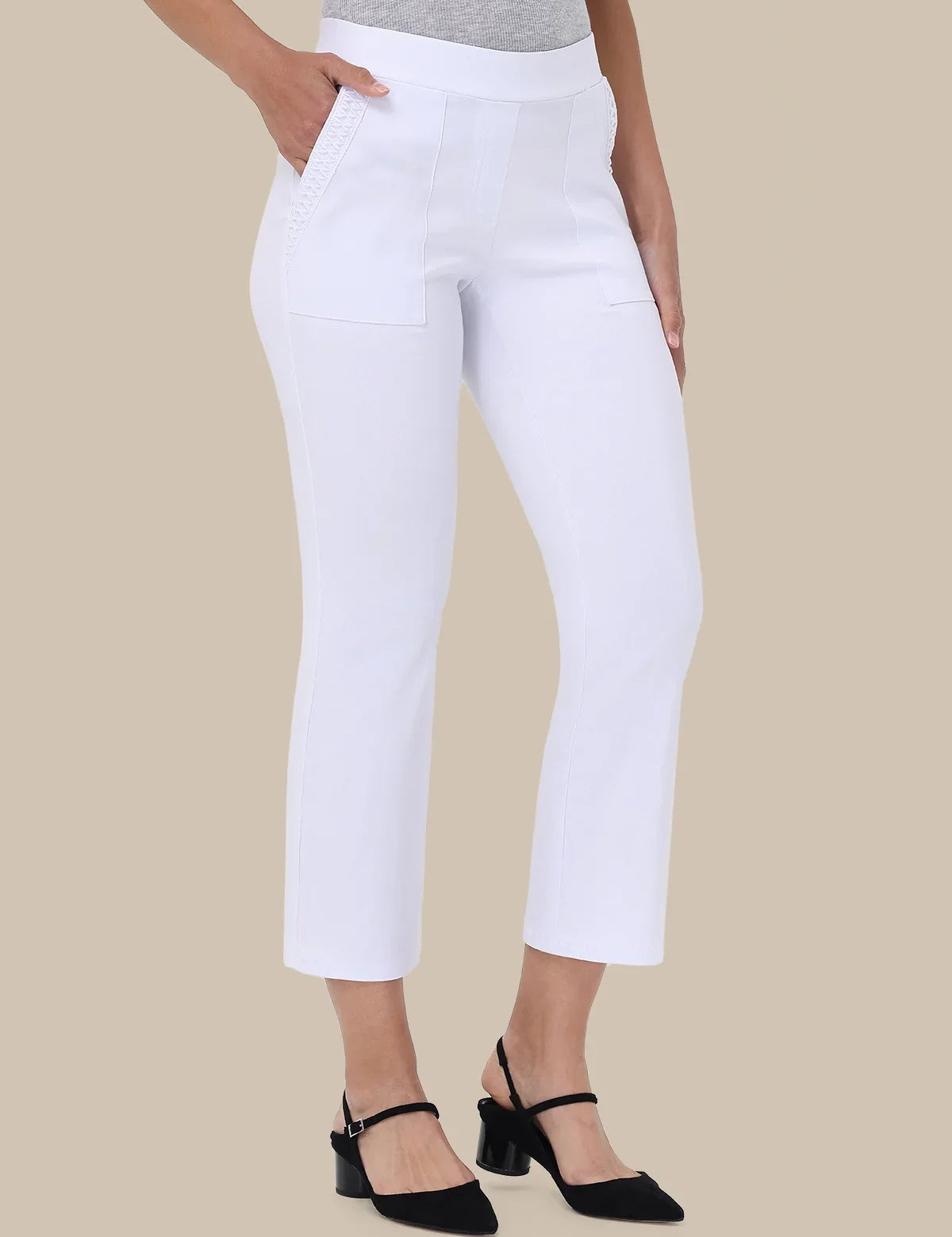 White cropped ankle-length pants with front patch pockets, shown on a model wearing a gray top and black heeled sandals against a beige studio background.