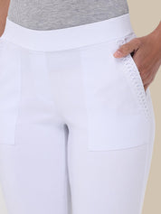 White riding breeches with a textured side panel and a wide waistband, shown on a model wearing a gray ribbed top against a light beige background.