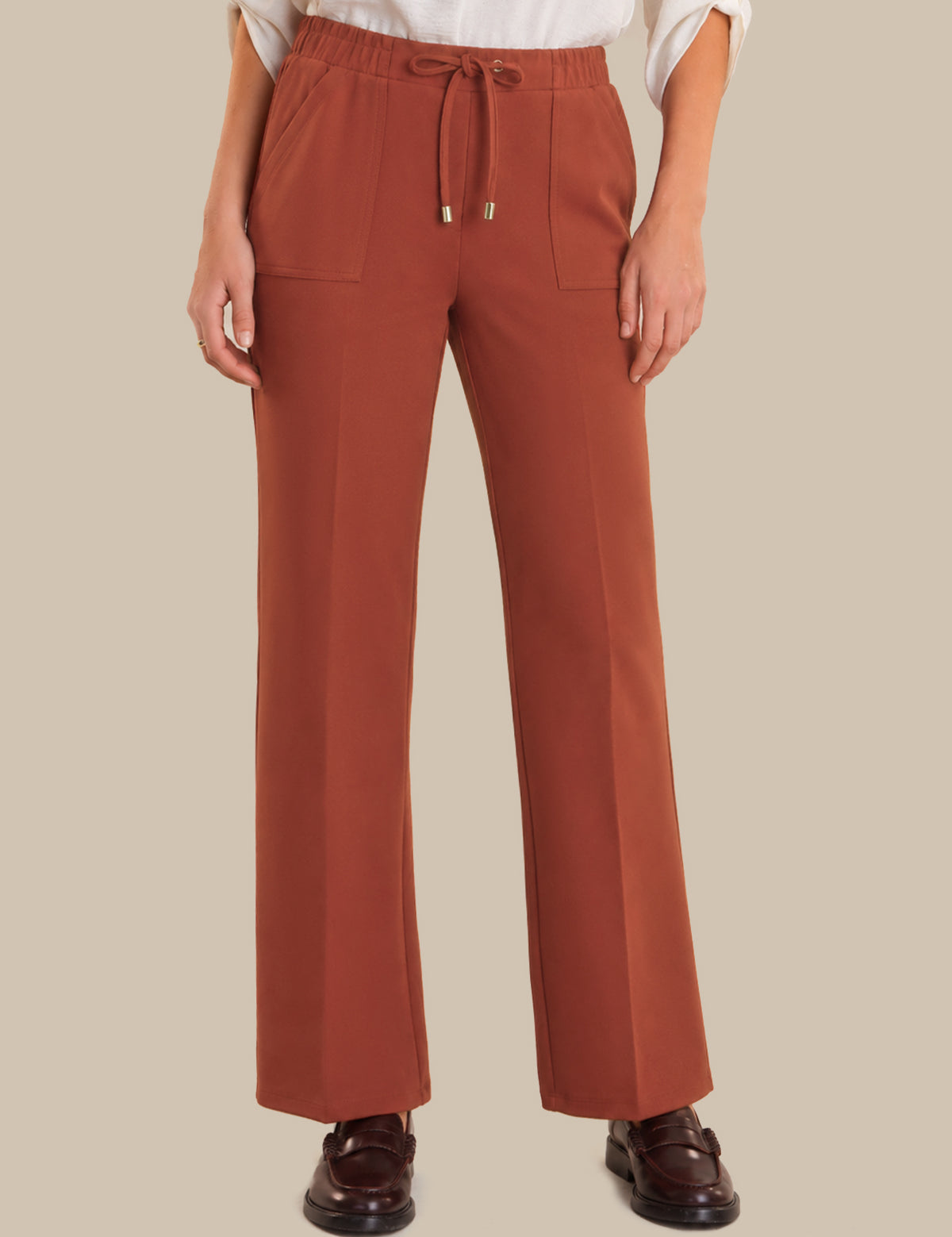 Red pants worn by a person on a beige background