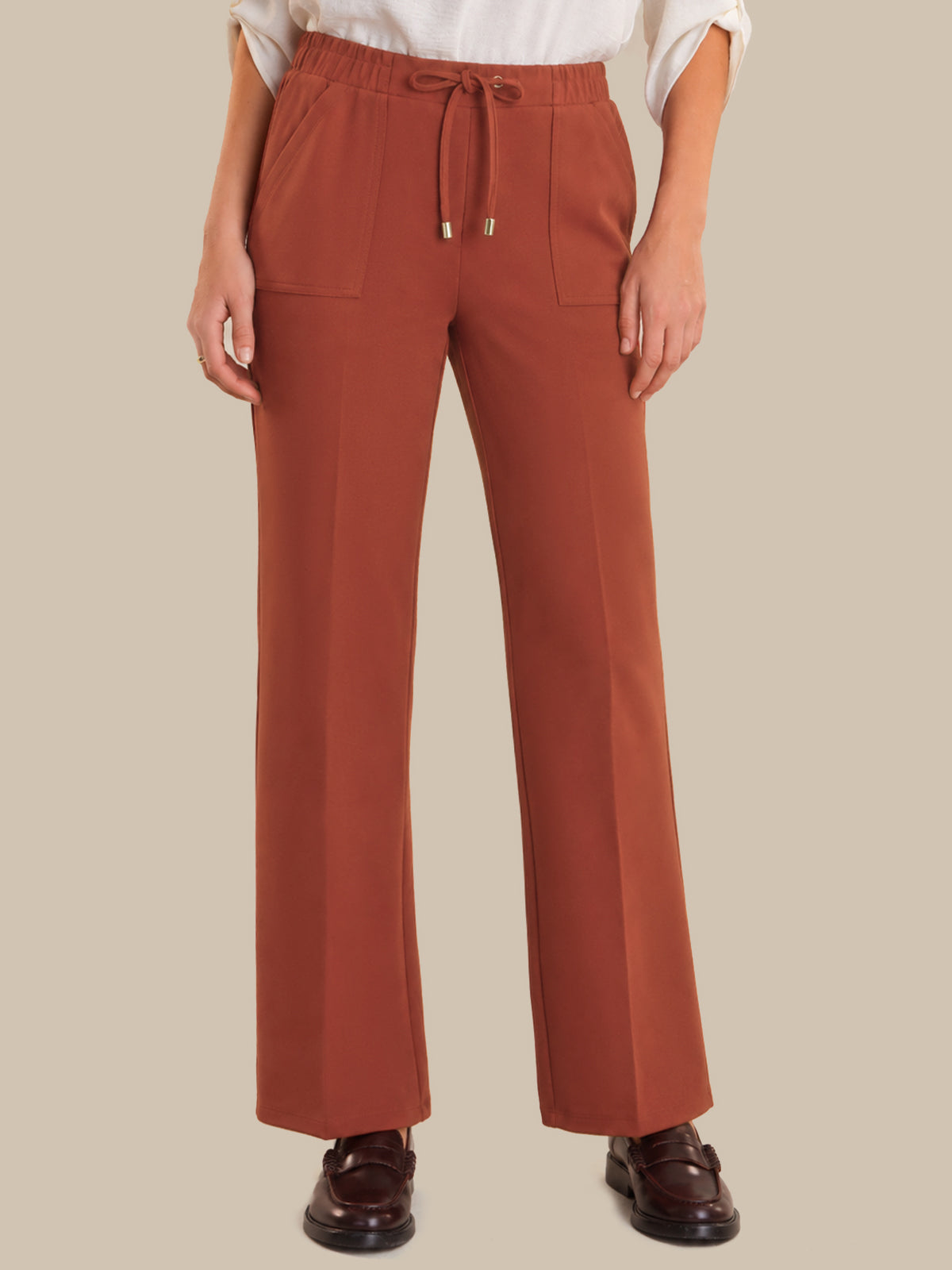 Red pants worn by a person on a beige background