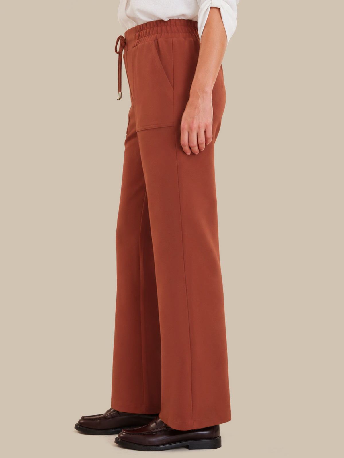 Red wide-leg pants worn by a person on a beige background