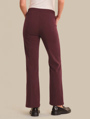 Maroon pants worn by a person on a beige background