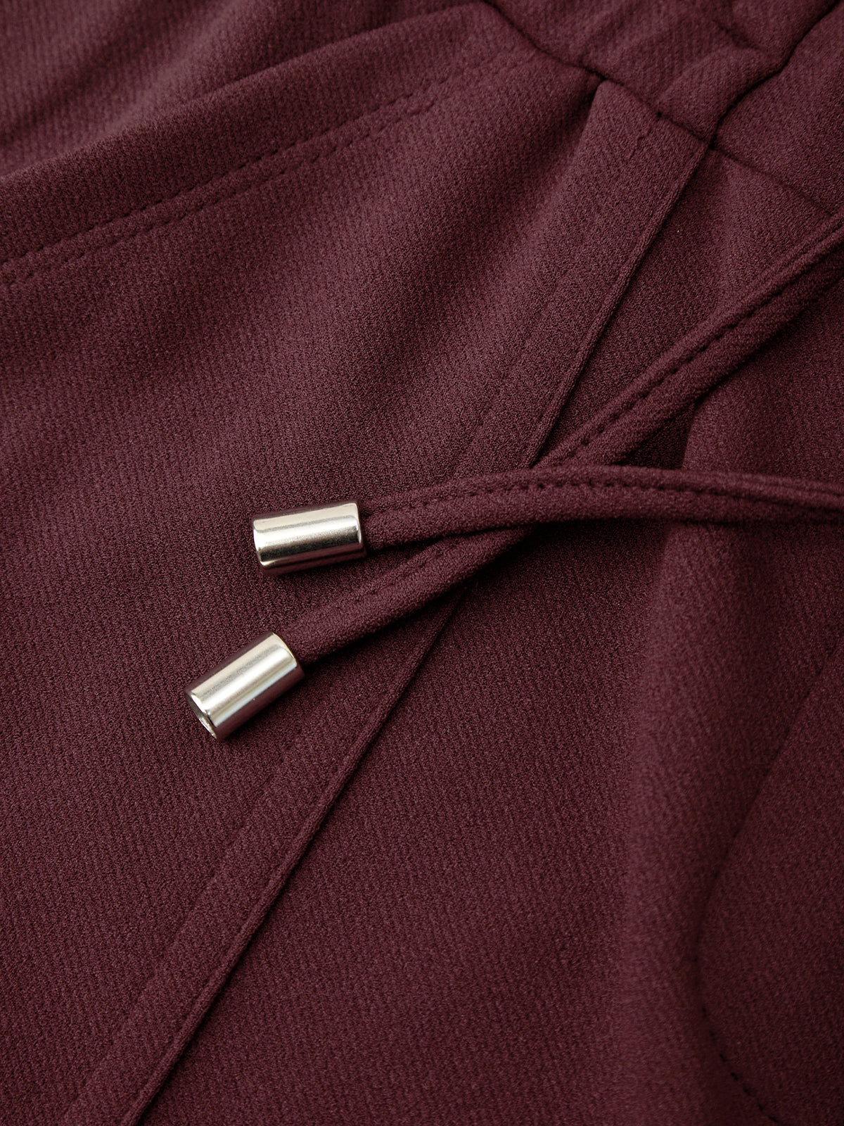 Close-up of a burgundy fabric with metal buttons