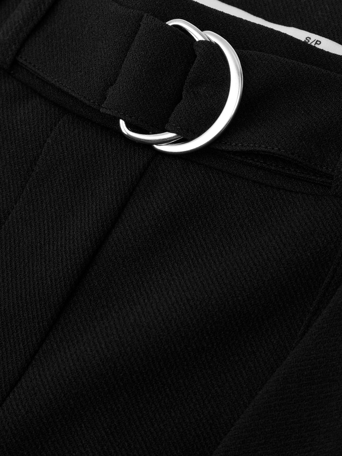 Close-up of a black belt with a silver buckle on a black background