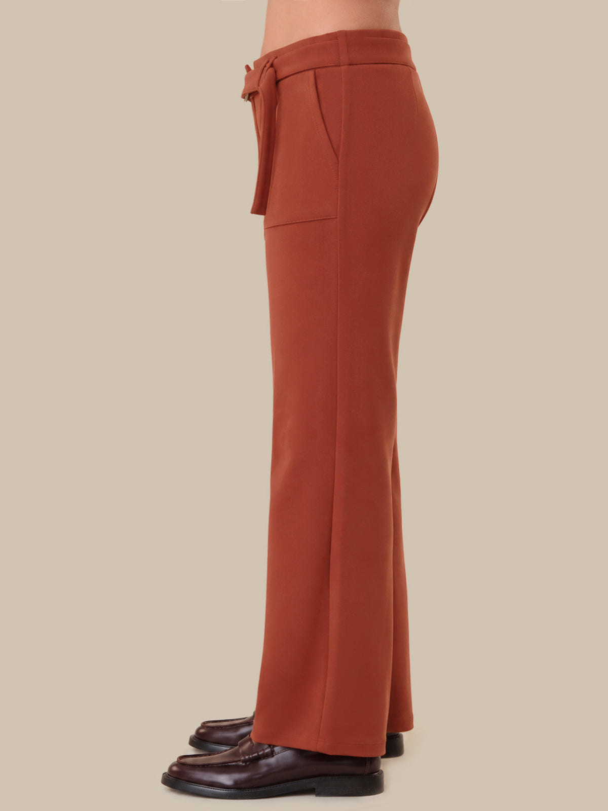 Brown wide-leg pants with a belt on a beige background