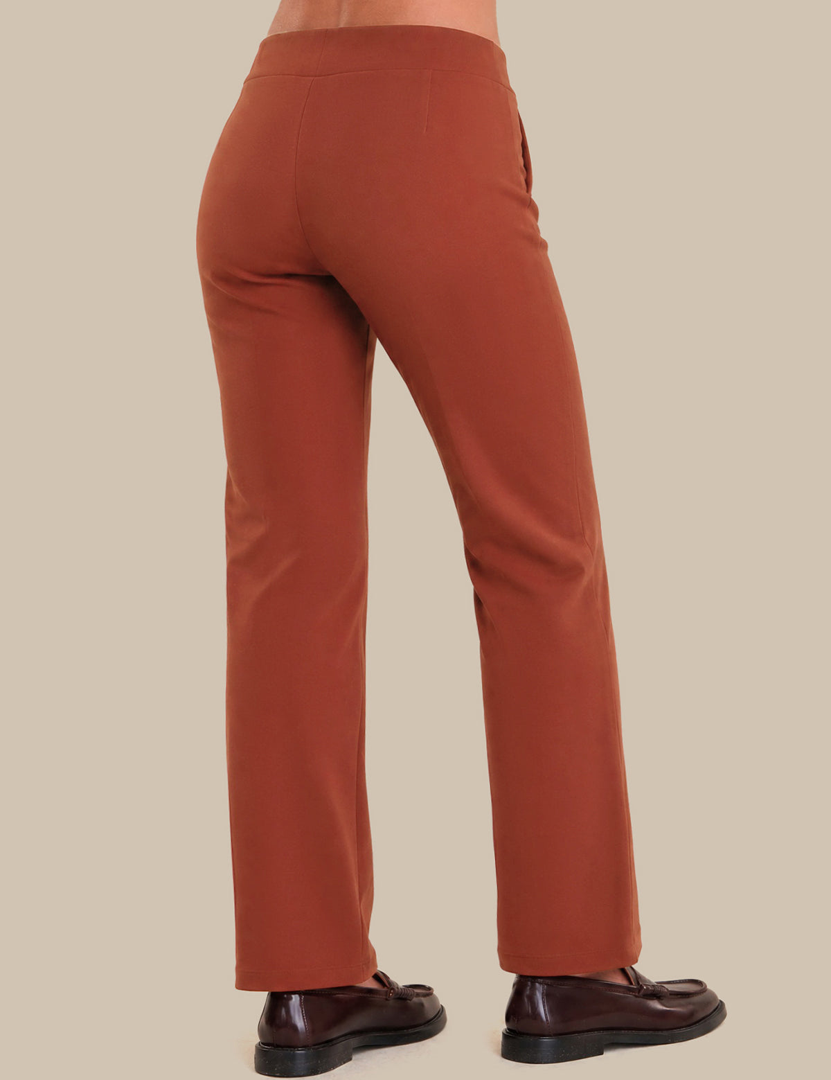 Brown pants worn by a person on a beige background