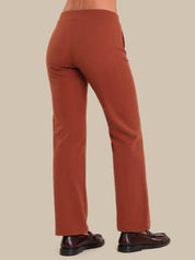 Brown pants worn by a person on a beige background