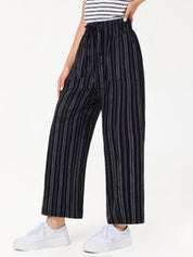 Person wearing black and white striped pants on a white background
