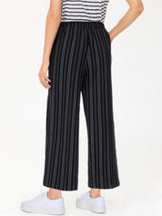 Person wearing black pinstripe pants with a white background