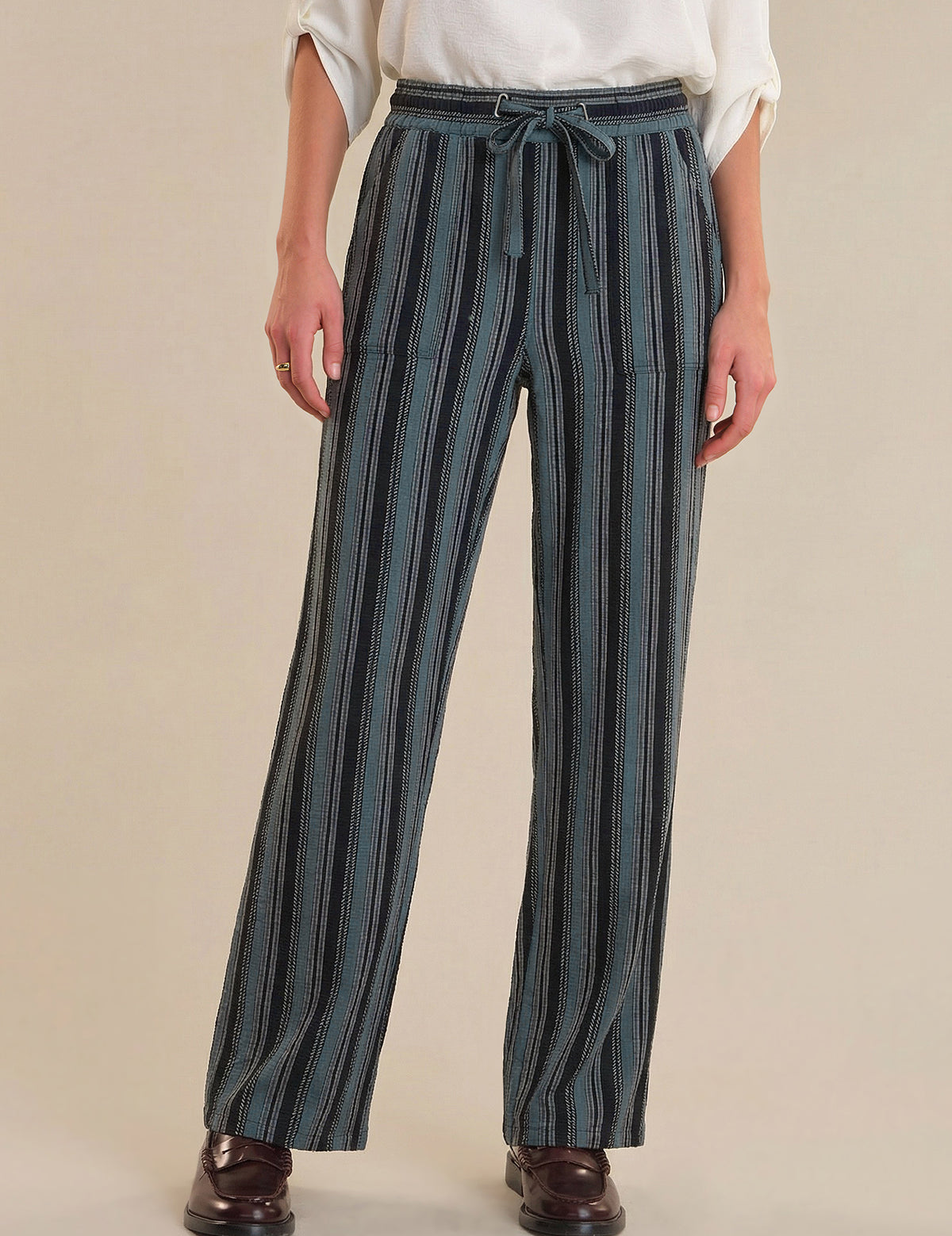 Person wearing blue striped pants on a beige background