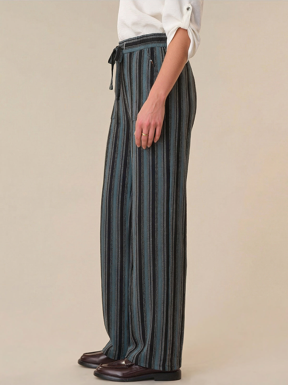 Person wearing striped pants with a plain background