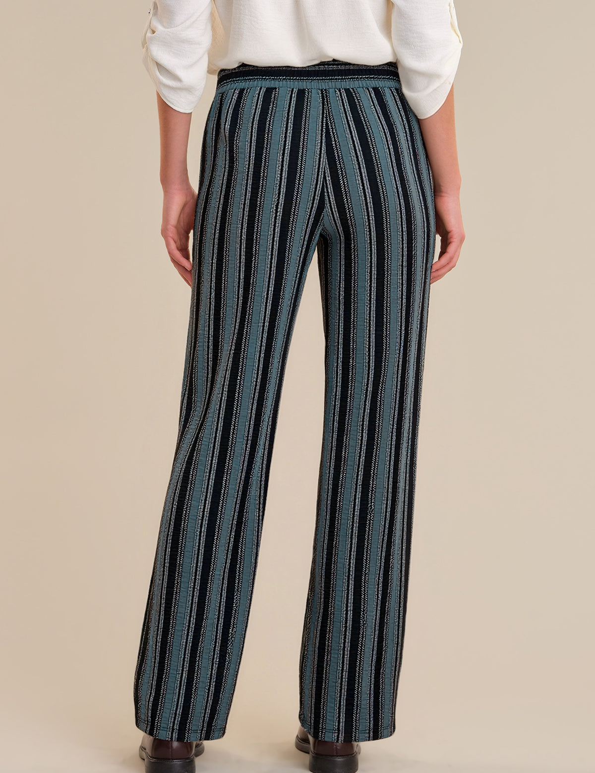 Person wearing blue striped pants on a beige background