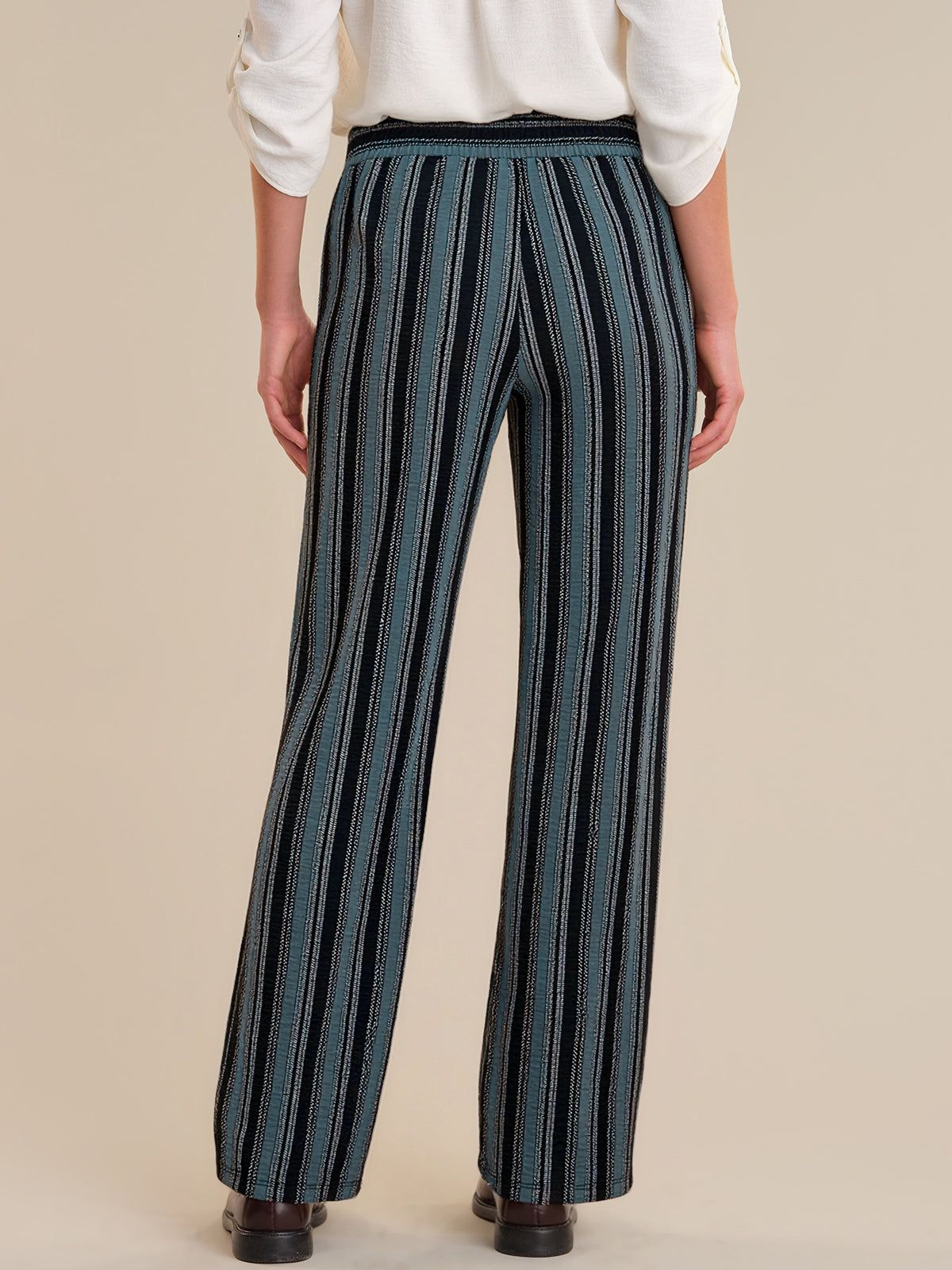 Person wearing blue striped pants on a beige background