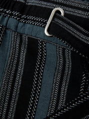 Close-up of a textured fabric with a metal clip on a black background