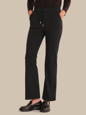 Person wearing black pants on a beige background