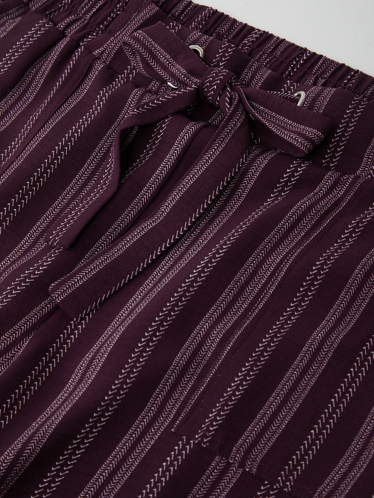Close-up of a maroon and white striped fabric with a subtle pattern.