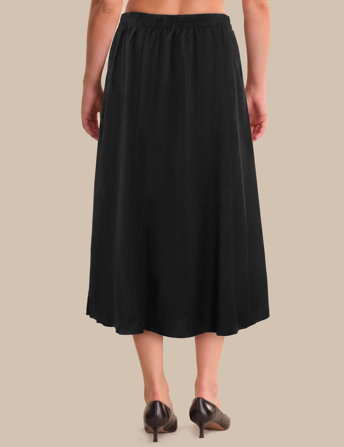 A black midi skirt with an elastic waistband, shown on a model from the back against a solid beige background.