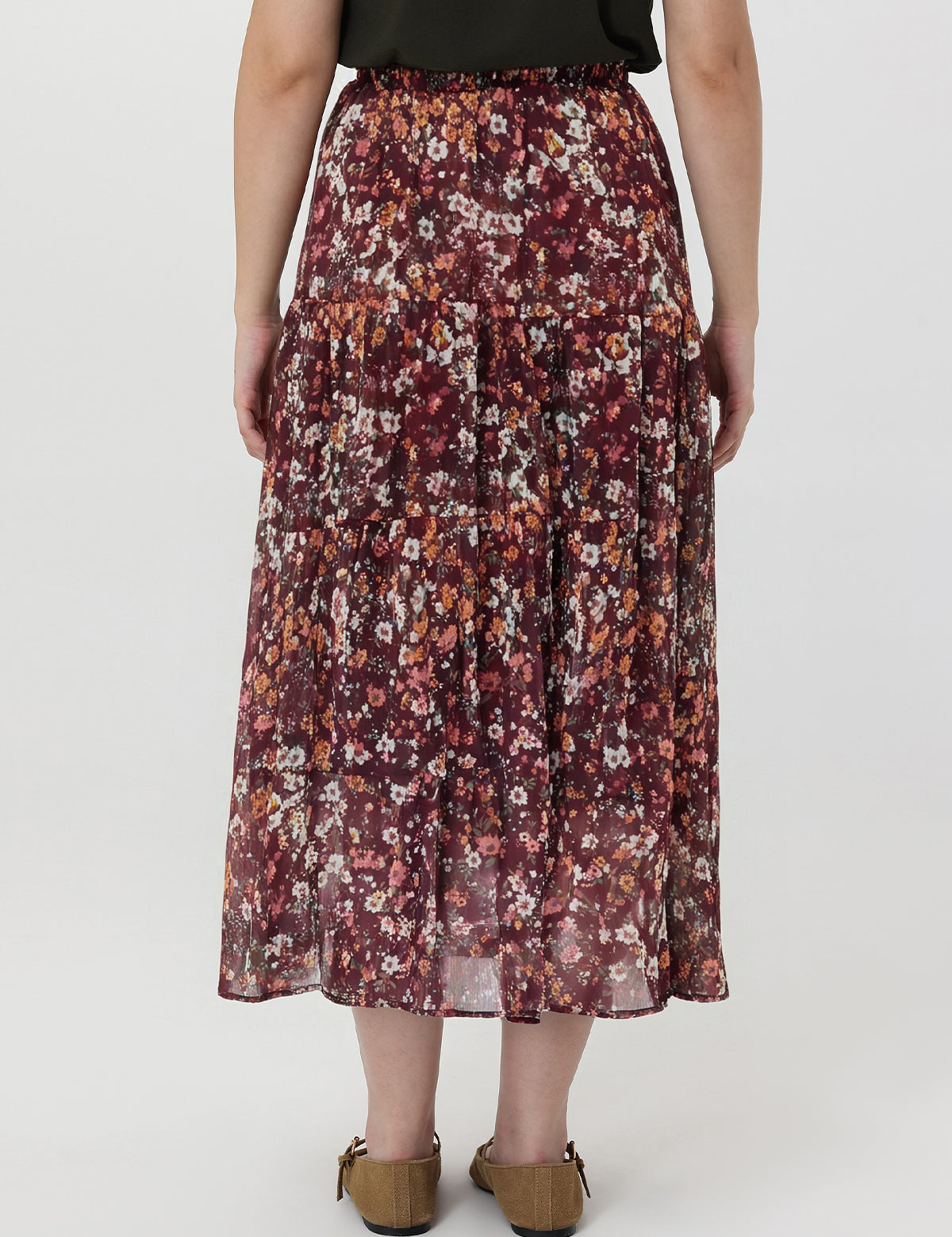Person wearing a floral skirt on a white background