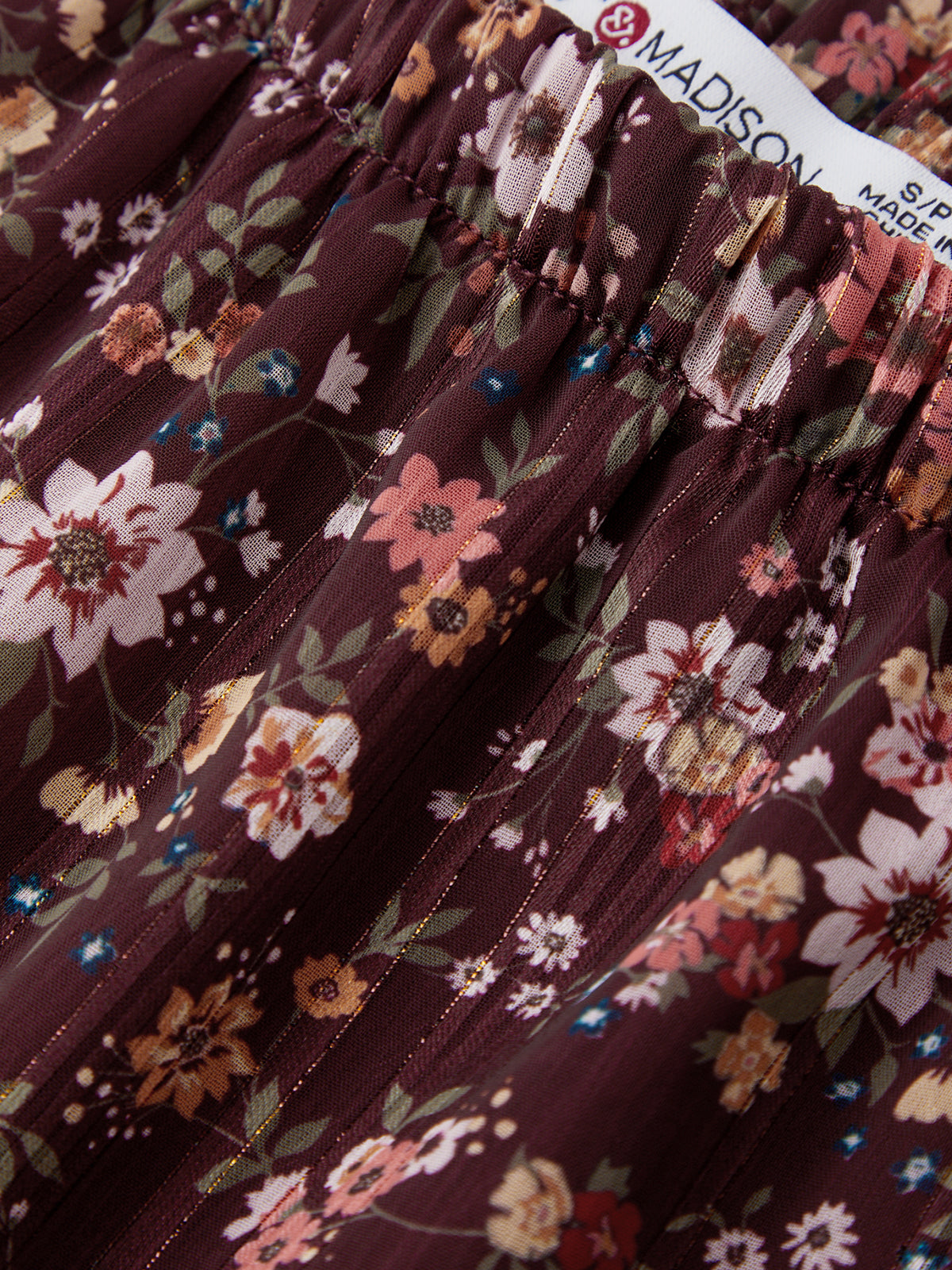 Close-up of a floral skirt with a brand tag in the background