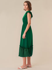 Woman wearing a green dress against a beige background