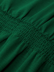 Close-up of green fabric with smocked waistband