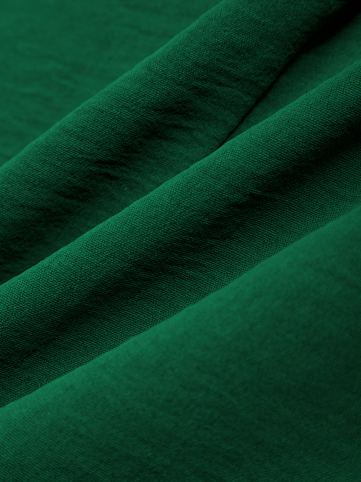 Close-up of dark green fabric with folds