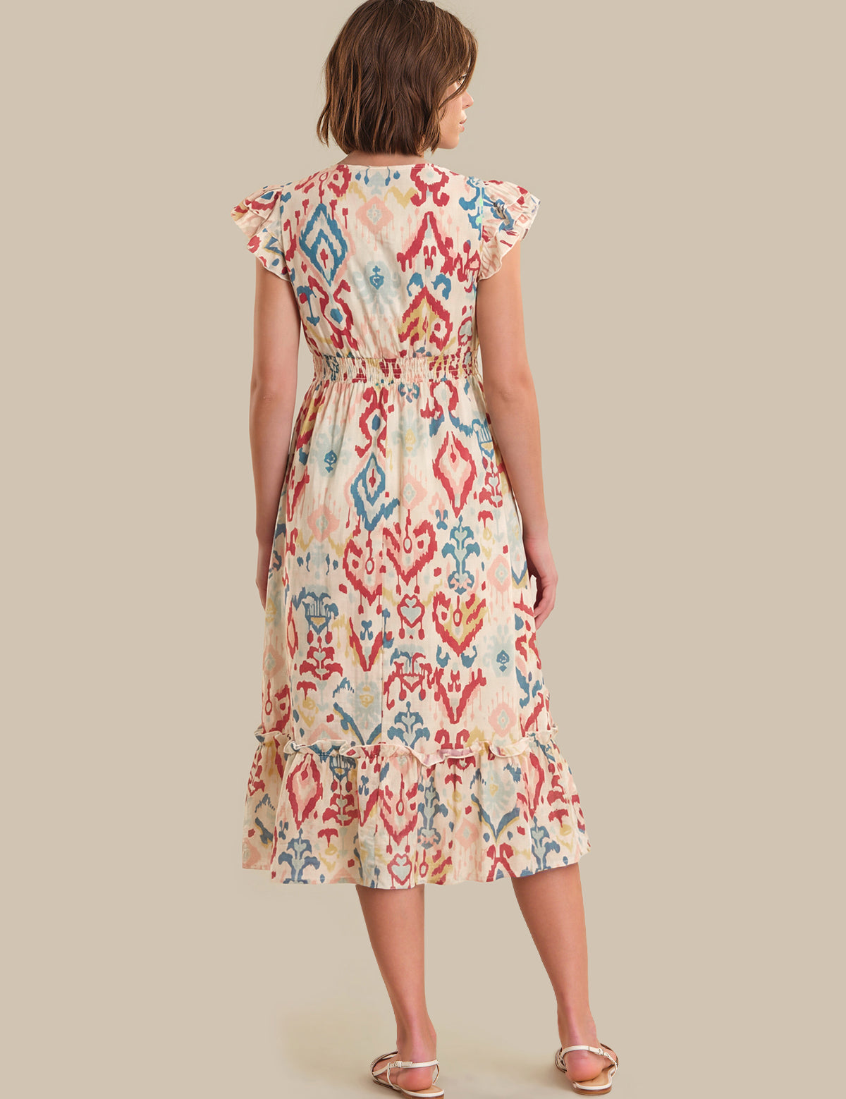 Woman wearing a patterned dress on a beige background