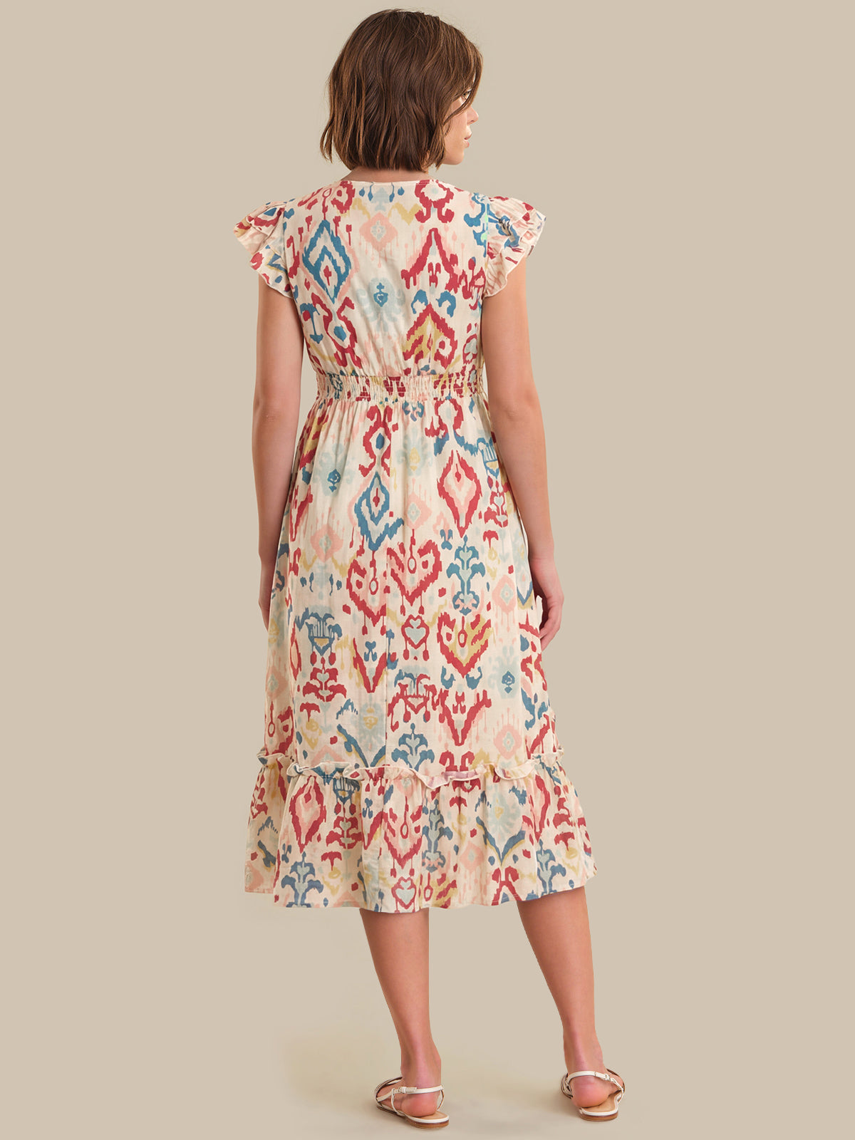 Woman wearing a patterned dress on a beige background