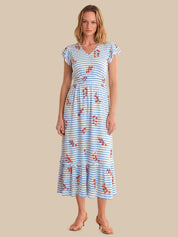 Woman wearing a blue and white striped dress with red floral patterns on a beige background