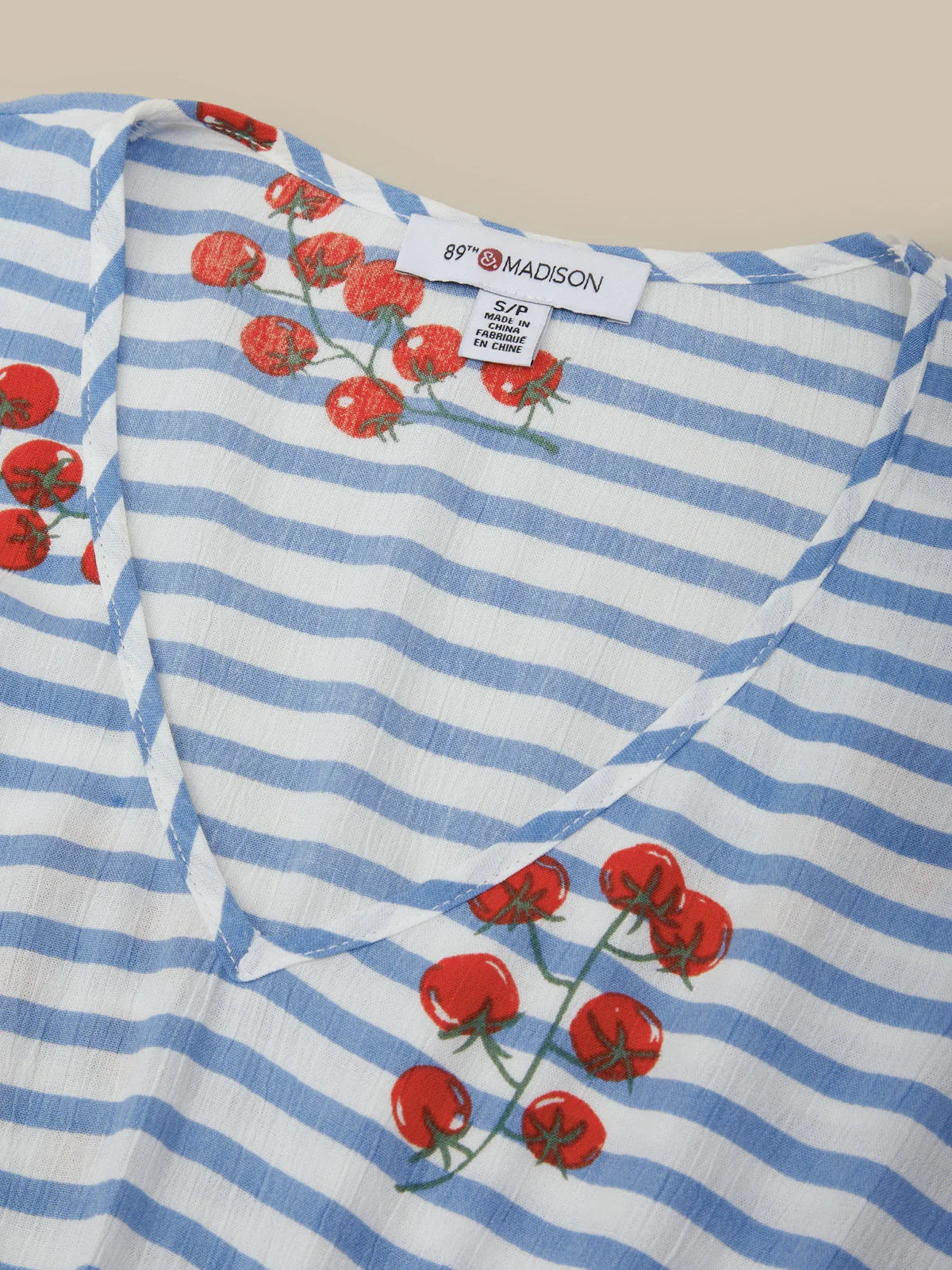 Blue and white striped fabric with red floral patterns and a visible label.