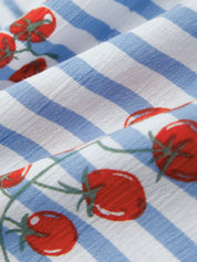 Close-up of a blue and white checkered fabric with red tomato pattern