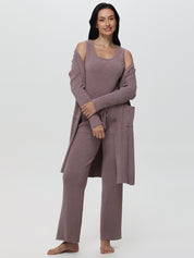 Woman wearing a mauve lounge set with a matching robe on a white background