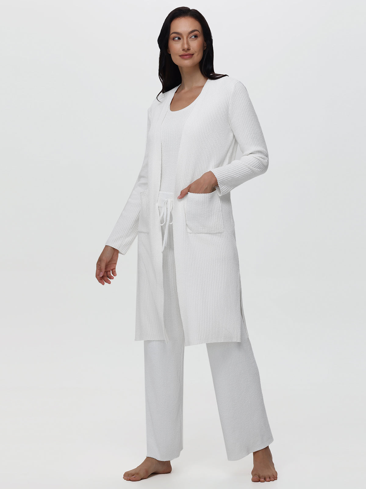 Woman wearing a white long-sleeve top and pants on a white background