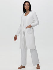 Woman wearing a white long-sleeve top and pants on a white background