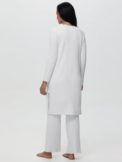 Person wearing a white outfit on a plain background