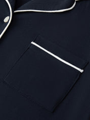 Navy blue pajama top with white piping on collar and pocket