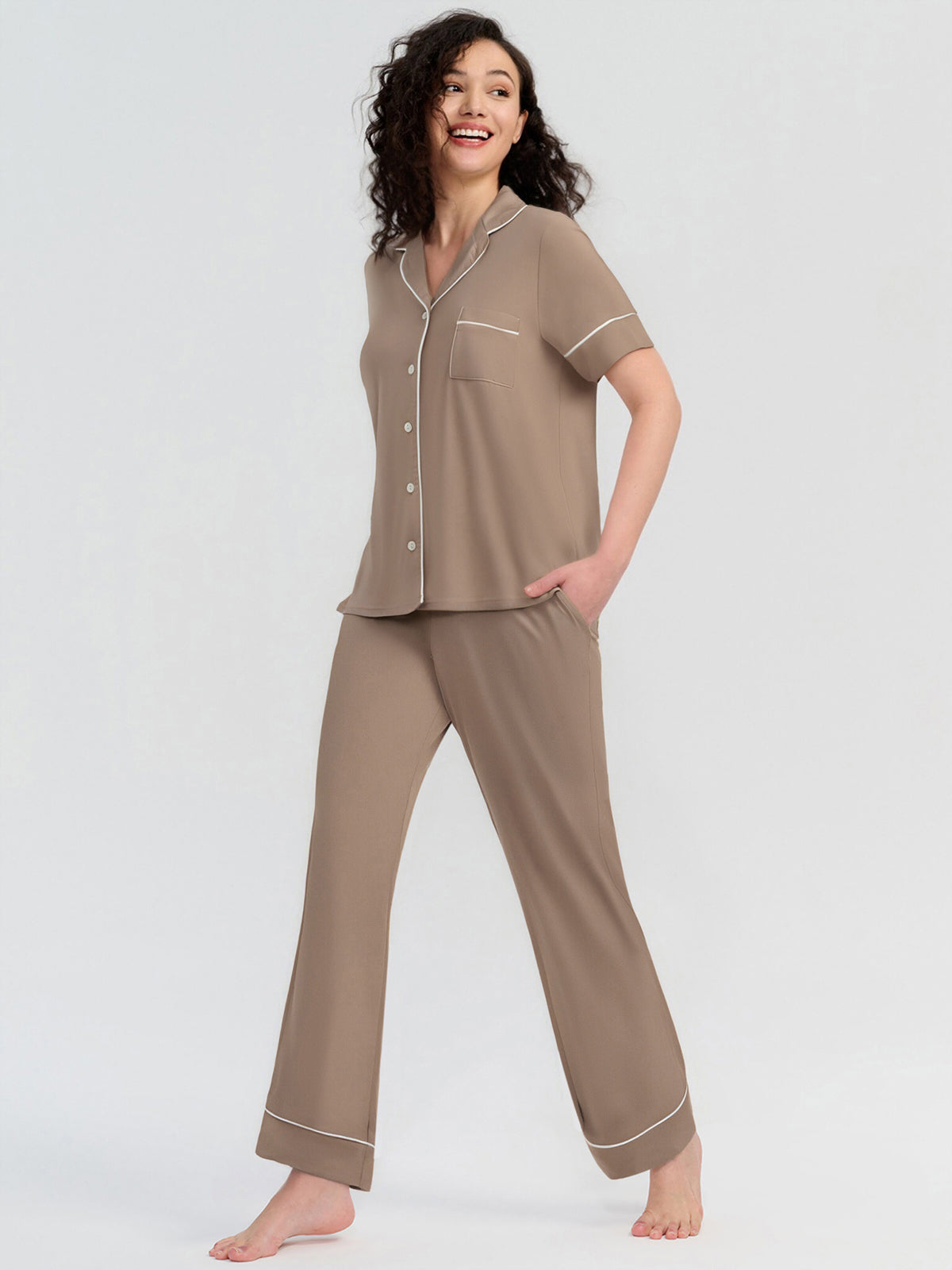 Woman wearing a brown pajama set on a white background